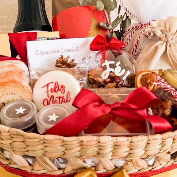 Cesta de Natal artesanal com biscoitos, cappuccino especial, castanhas, doces caseiros, laços vermelhos e decoração temática.